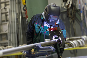 Image showing Industrial worker setting orbital welding machine.