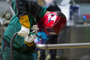 Image showing Industrial worker welding in metal factory.