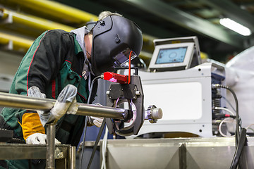 Image showing Industrial worker setting orbital welding machine.