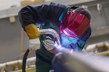 Image showing Industrial worker welding in metal factory.