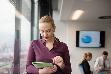 Image showing blonde businesswoman working on tablet at office