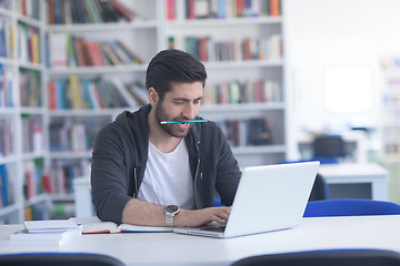 Image showing student in school library using laptop for research