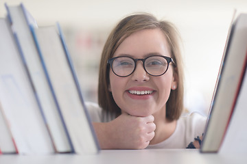 Image showing portrait of famale student selecting book to read in library