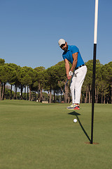 Image showing golf player hitting shot at sunny day