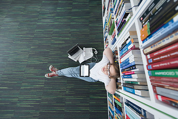 Image showing female student study in library, using tablet and searching for 