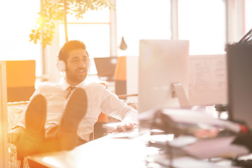 Image showing relaxed young businessman first at workplace at early morning