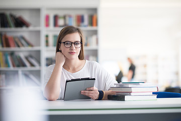 Image showing female student study in school library, using tablet