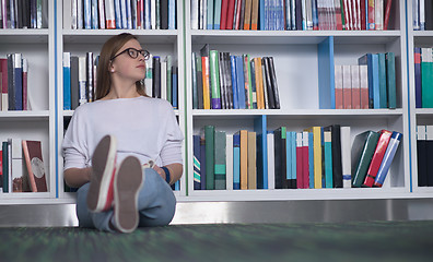 Image showing female student study in library, using tablet and searching for 