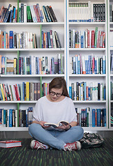 Image showing famale student reading book in library