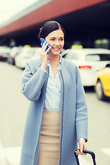 Image showing smiling woman with smartphone over taxi in city