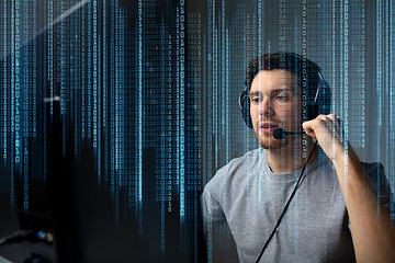 Image showing man in headset playing computer video game at home