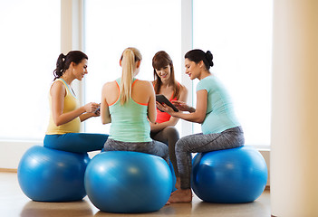 Image showing happy pregnant women with gadgets in gym