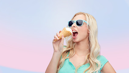 Image showing happy young woman in sunglasses eating ice cream