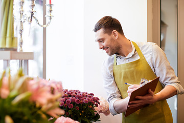 Image showing florist man with clipboard at flower shop