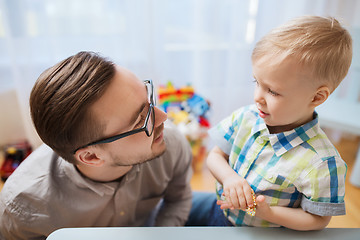 Image showing father and son playing with ball clay at home