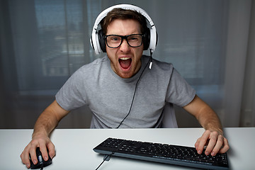 Image showing man in headset playing computer video game at home