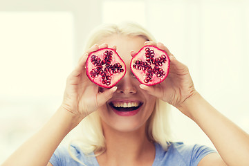 Image showing happy woman covering eyes with pomegranate