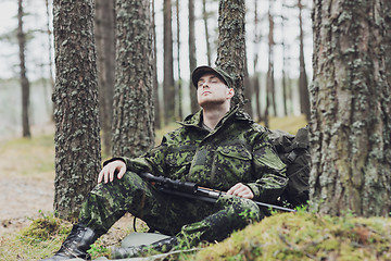 Image showing soldier or hunter with gun sleeping in forest