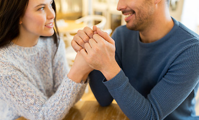 Image showing happy couple holding hands at restaurant or cafe