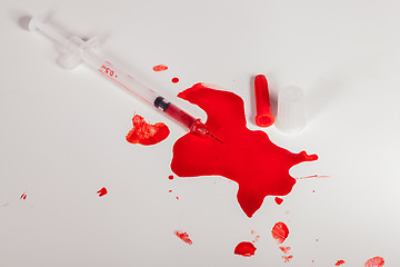 Image showing Syringe Squirting Red Blood onto White Background