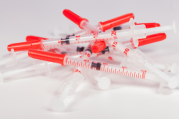 Image showing Pile of Empty Syringes with Red Safety Caps