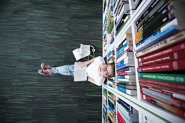 Image showing female student study in library, using tablet and searching for 