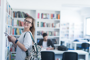 Image showing famale student selecting book to read in library