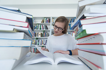 Image showing female student study in library, using tablet and searching for 