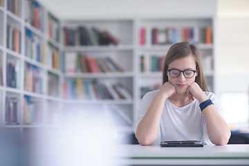 Image showing female student study in school library, using tablet