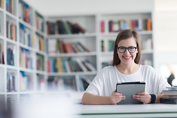 Image showing female student study in school library, using tablet