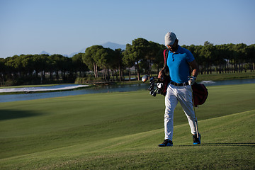 Image showing golf player walking and carrying bag