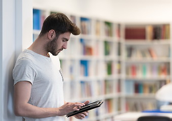 Image showing student in school library using tablet for research