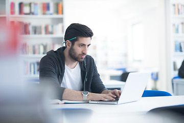 Image showing student in school library using laptop for research