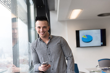 Image showing young business man using smart phone at office