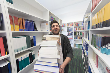 Image showing Student holding lot of books in school library