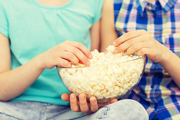 Image showing close up of kids with popcorn bowl eating