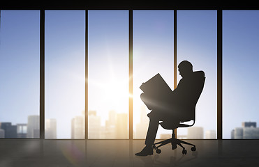 Image showing silhouette of businessman reading documents