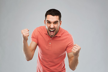 Image showing happy man celebrating victory over gray background