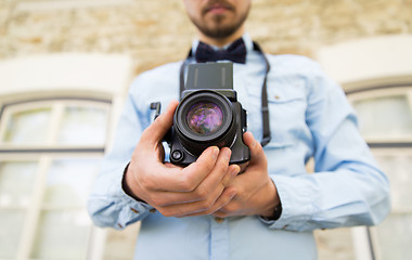 Image showing close up of hipster man with film camera in city