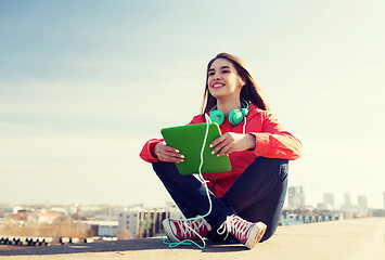 Image showing happy young woman with tablet pc and headphones