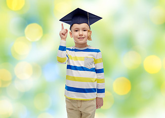 Image showing happy boy in bachelor hat pointing finger up