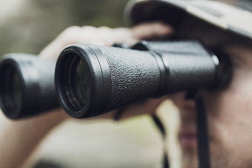 Image showing close up of soldier or hunter with binocular