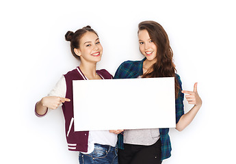 Image showing smiling teenage girls holding white blank board