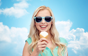 Image showing happy young woman in sunglasses eating ice cream