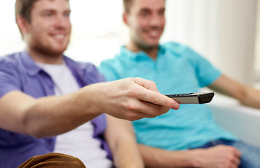 Image showing happy male friends with remote watching tv at home