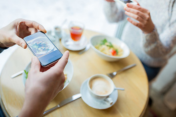 Image showing close up of couple picturing food by smartphone