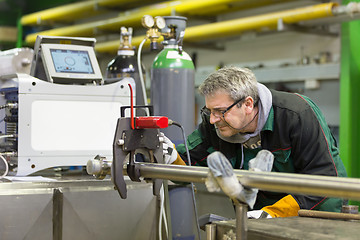 Image showing Industrial worker setting orbital welding machine.