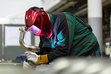 Image showing Industrial worker welding in metal factory.