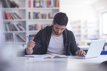 Image showing student in school library using laptop for research