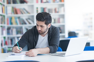 Image showing student in school library using laptop for research